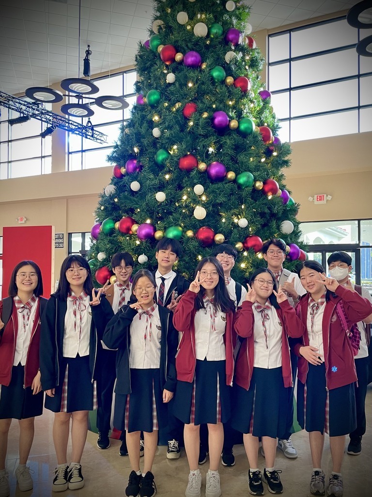visiting students in front of Christmas tree